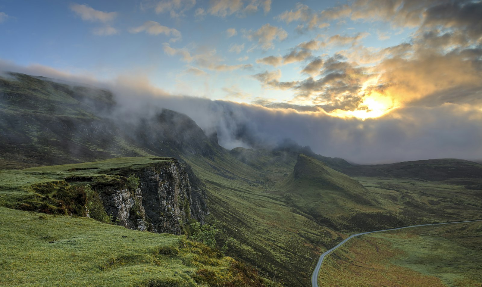 Green ridge above a winding valley road