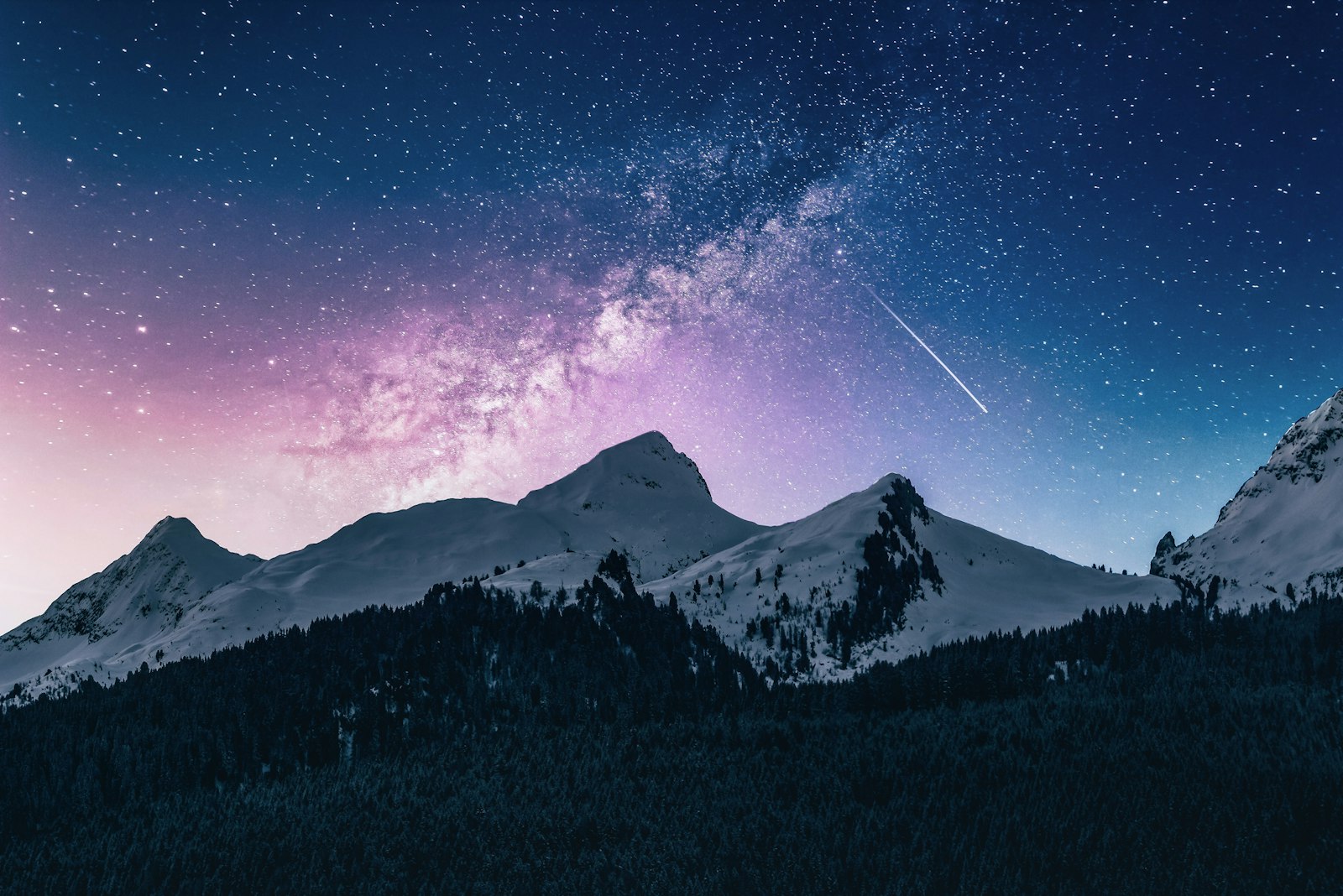 Night sky and the Milky Way above snowy peaks