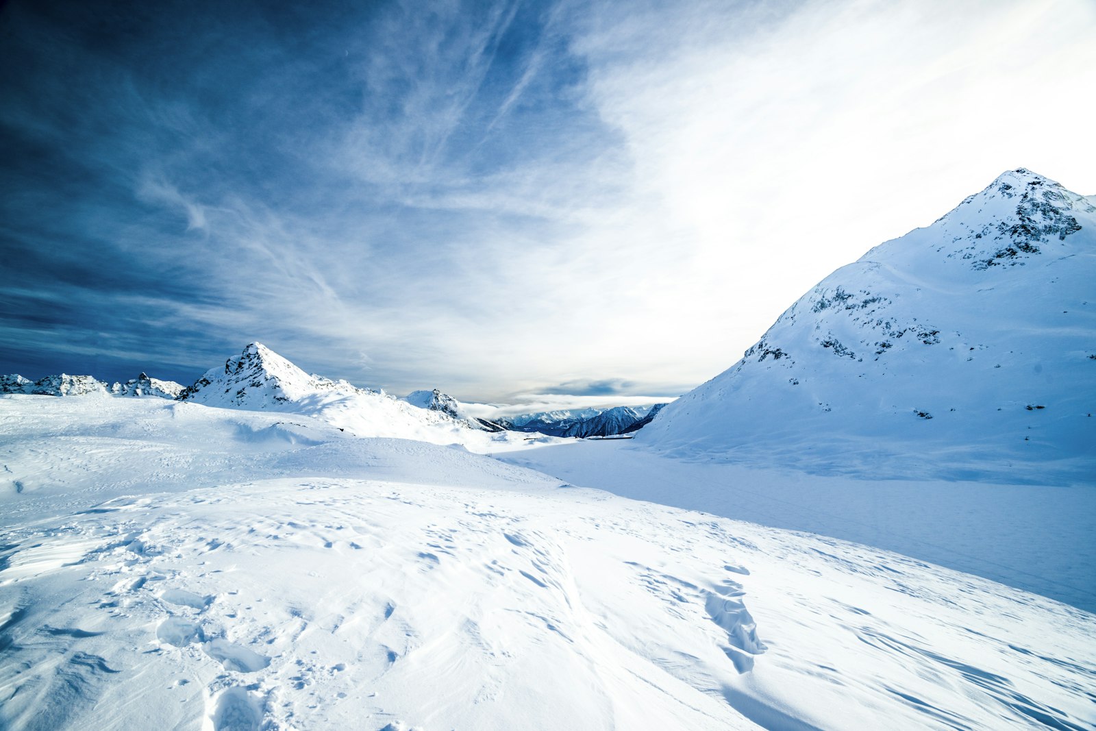 A wide snowfield under a deep blue sky