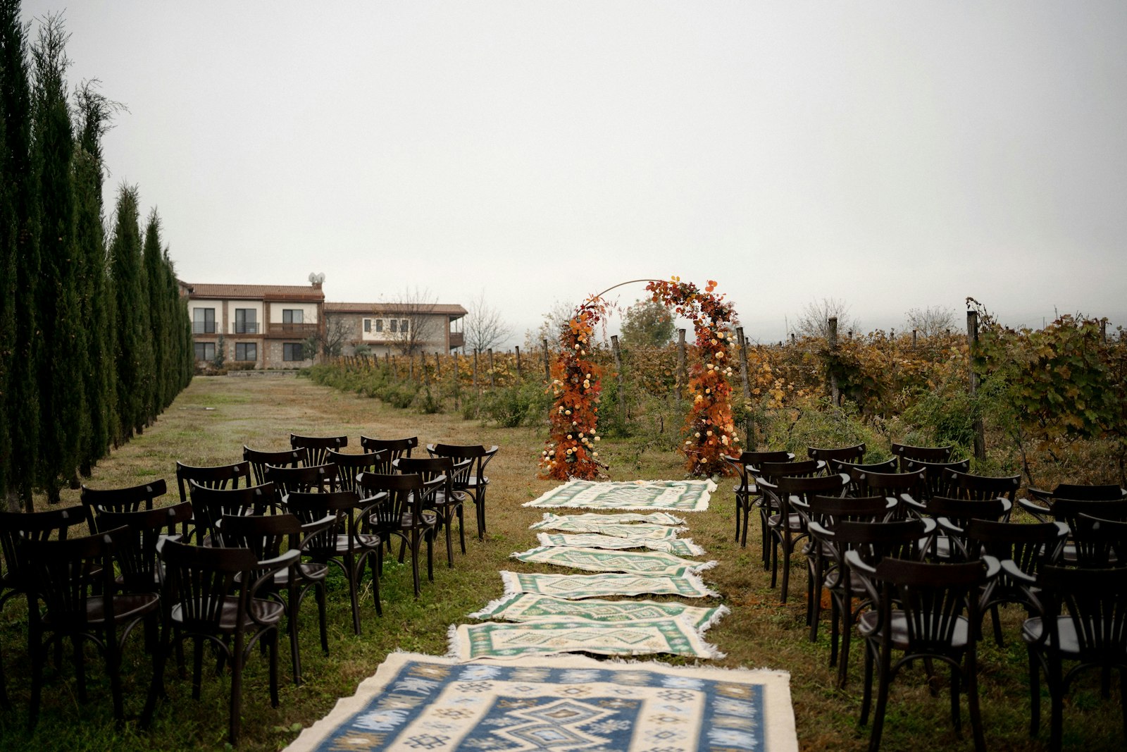 Ceremony aisle with rows of chairs leading to a flower arch